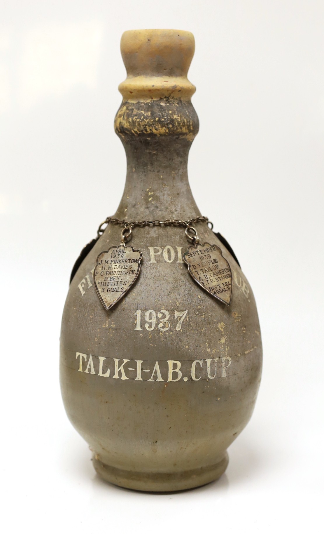 A pottery vase from Fields Polo Club 'The Talk-1-AB Cup', with four white metal badges on a chain engraved with the winners from 1937, 1938, 1939 and 1945, 35cm